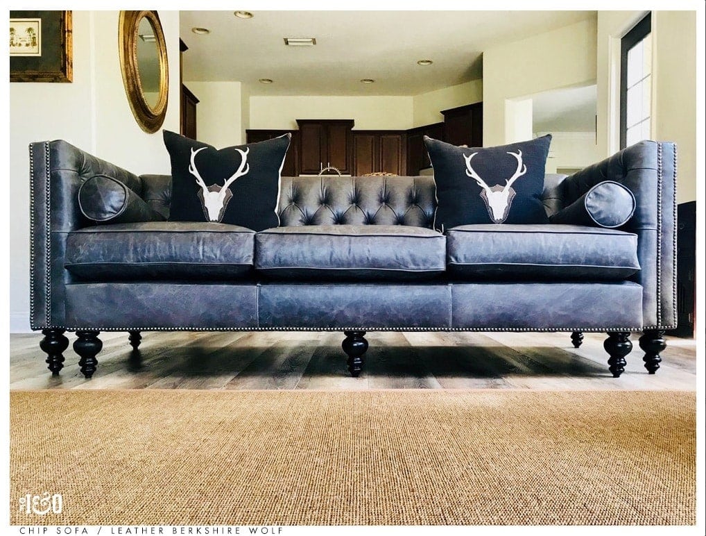 Custom designed from the ground up. Navy blue leather hand-tufted Chesterfield sofa with 7 legs, recessed arms, and matching bolster pillows.